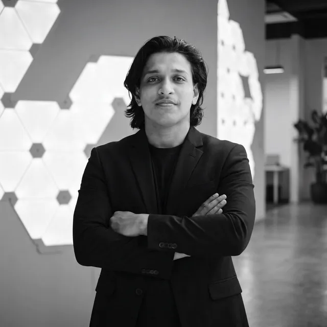 Adil Rafeeque, arms crossed, in a black blazer