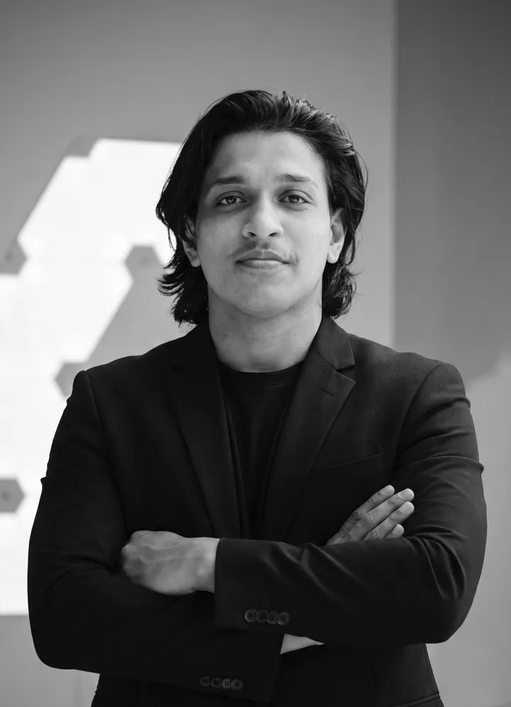 Adil Rafeeque, arms crossed, in a black blazer